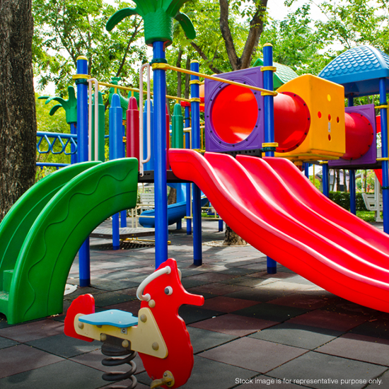 Kids outdoor playground with slides, tunnels, and play equipment in a green park.