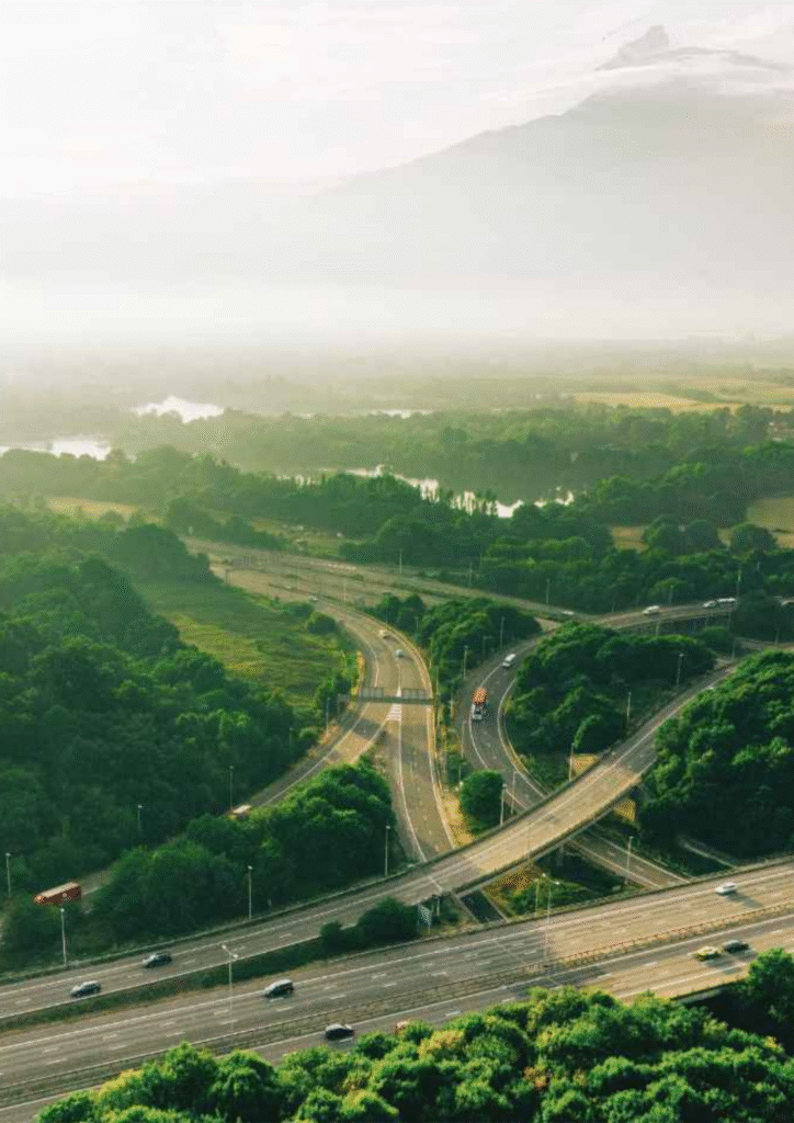 Aerial view of a multi-lane highway surrounded by greenery, representing strong road connectivity near Godrej Verdania Estate.