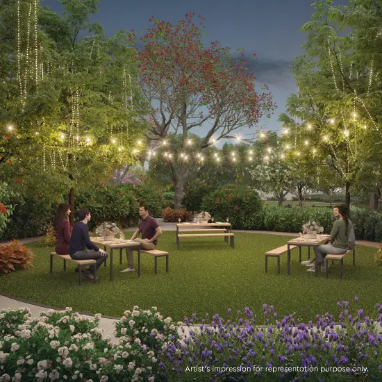 Outdoor seating area with decorative hanging lights in a landscaped garden.